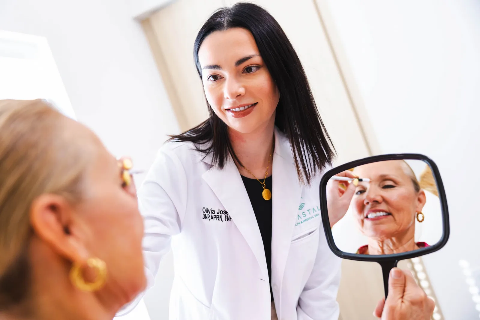 A Coastal Health & Medical Spa patient in Jacksonville looking in the mirror applying skincare after her CO2 laser resurfacing session