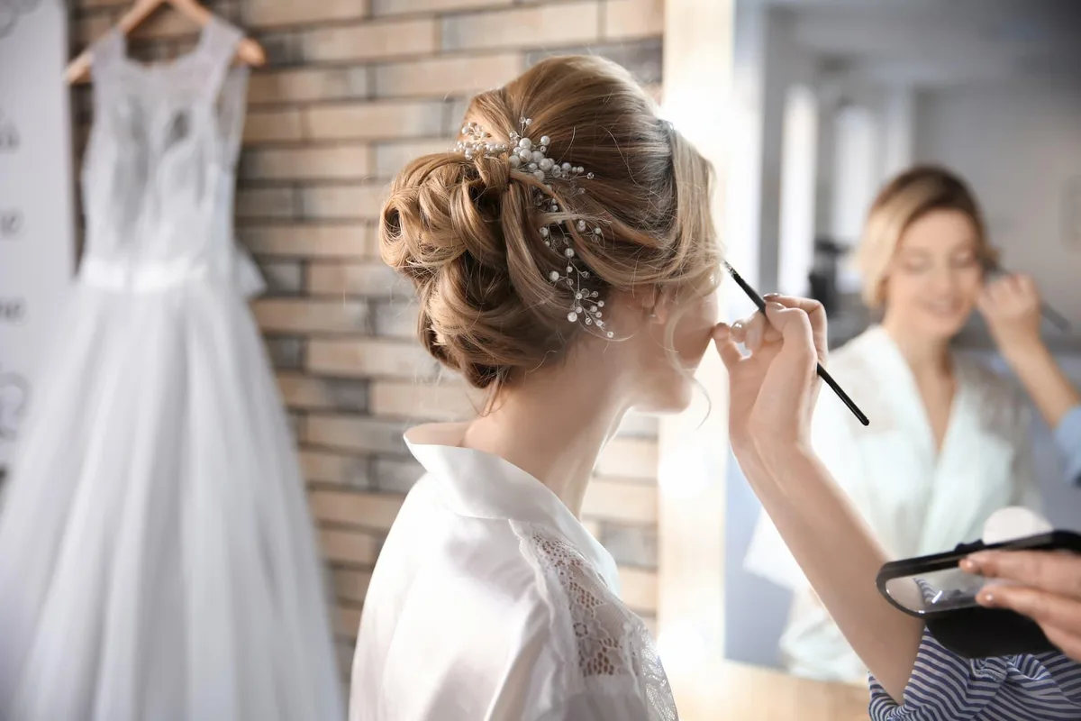 A bride-to-be in the dressing room before her wedding, prepping her skin for wedding makeup with the natural glow that comes from a bridal facial series.