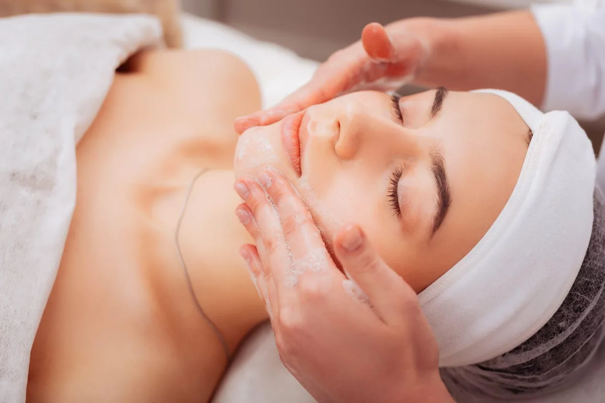 A woman receiving the deep cleanse step of a brightening facial, the first stage before dermaplaning and the ZO Stimulator Peel.