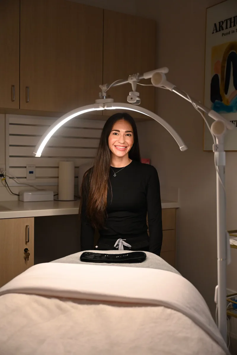 Danielle Hancock, Licensed Aesthetician, beside the treatment bed where facials are performed at Coastal Health & Medical Spa in Jacksonville