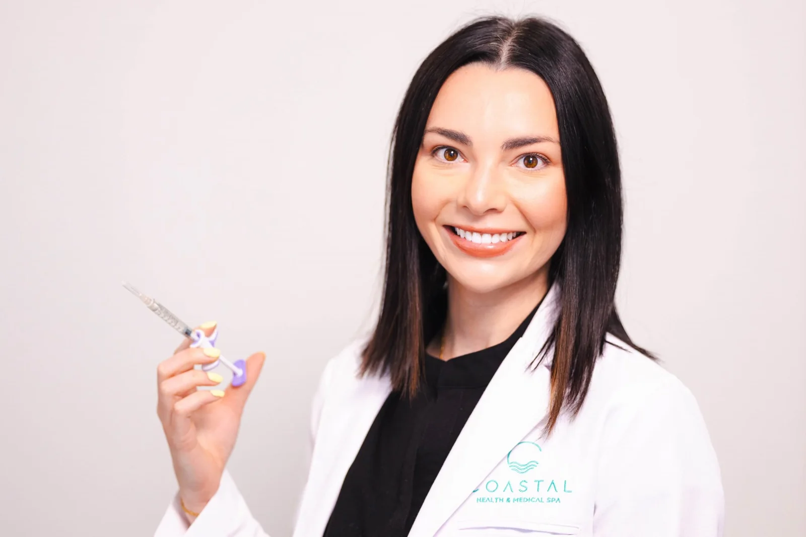 Dr. Olivia Jose, Nurse Practitioner, holding a dermal filler syringe before a jawline filler treatment at Coastal Health & Medical Spa in Jacksonville, FL
