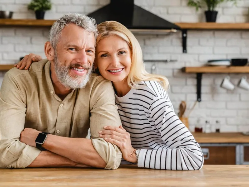 Smiling middle-aged couple at home, representing renewed connection through men's sexual health treatment in Jacksonville, FL
