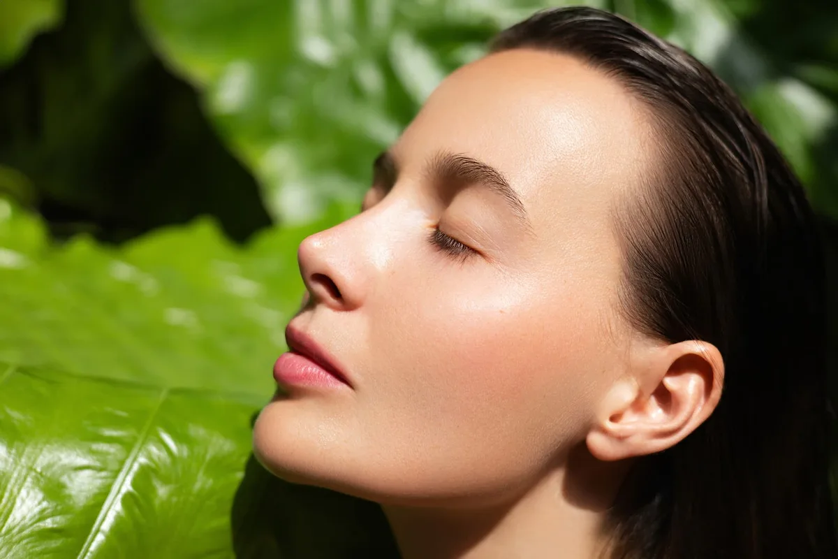 A woman with calm, glowing skin around day 7 of microneedling aftercare, when redness and sensitivity have settled.