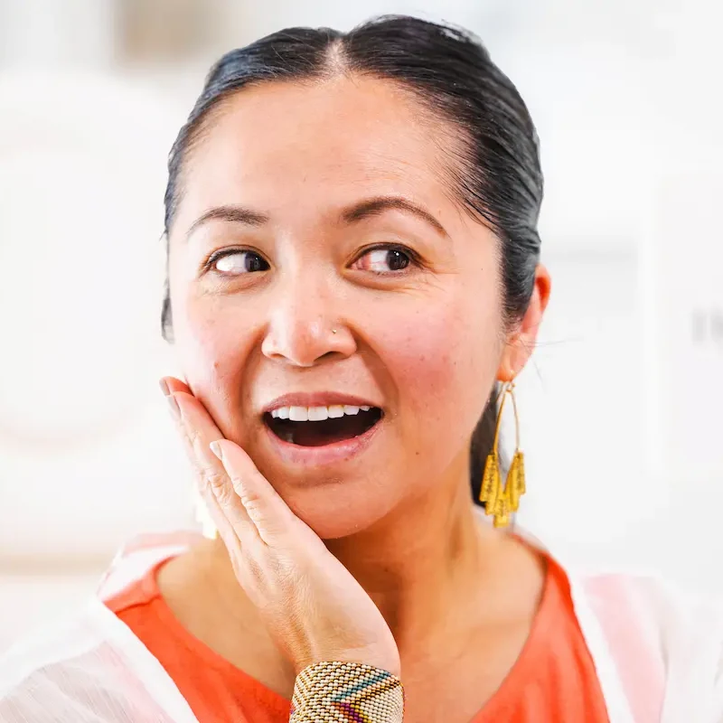 A smiling patient holding her HydraFacial card after treatment at Coastal Health & Medical Spa in Jacksonville, FL