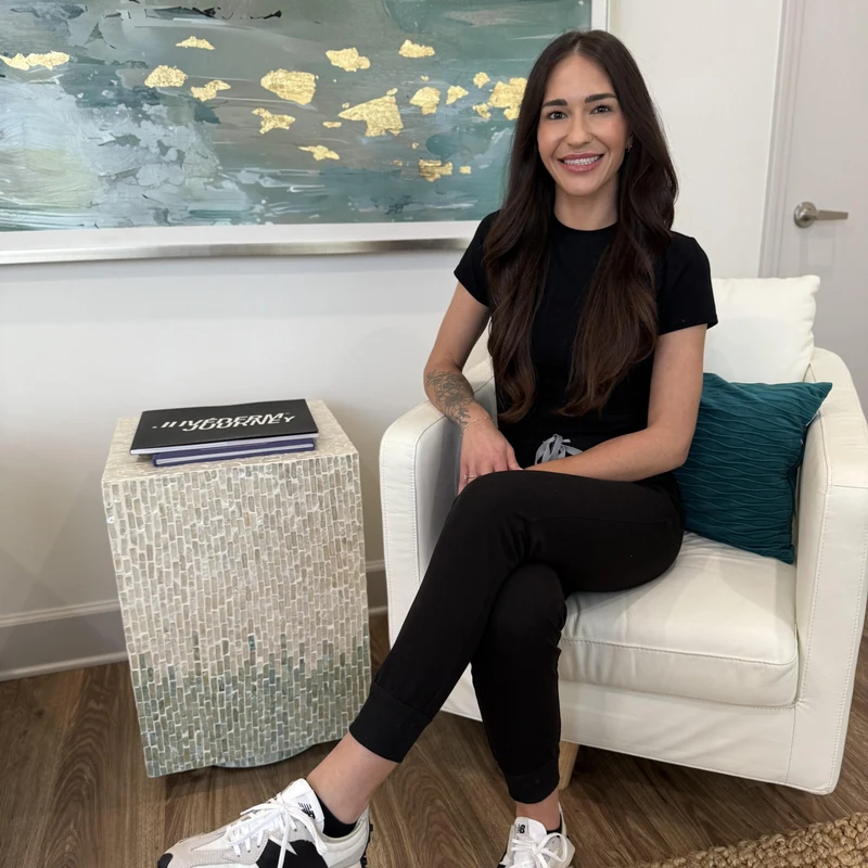 Danielle Hancock, Licensed Aesthetician, seated in the lounge at Coastal Health & Medical Spa in Jacksonville, where every lymphatic drainage facial begins with a free skin consultation